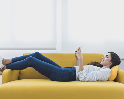 woman laying on a couch on her phone
