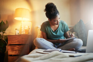 Cropped shot of a young female during her bedtime routine student journaling at home before she goes to bed